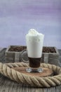 Caffe mocha with whipped cream. Latte macchiato in a tall glass. Glass of coffee latte and coffee beans on a dark background. ÃÂ¡